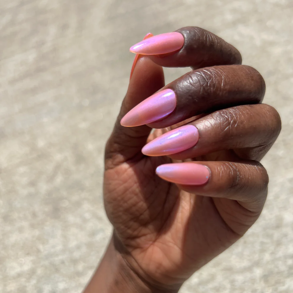 Hand with pink and purple nail polish against a neutral background. Available at Luca Essentials in Los Angeles. 