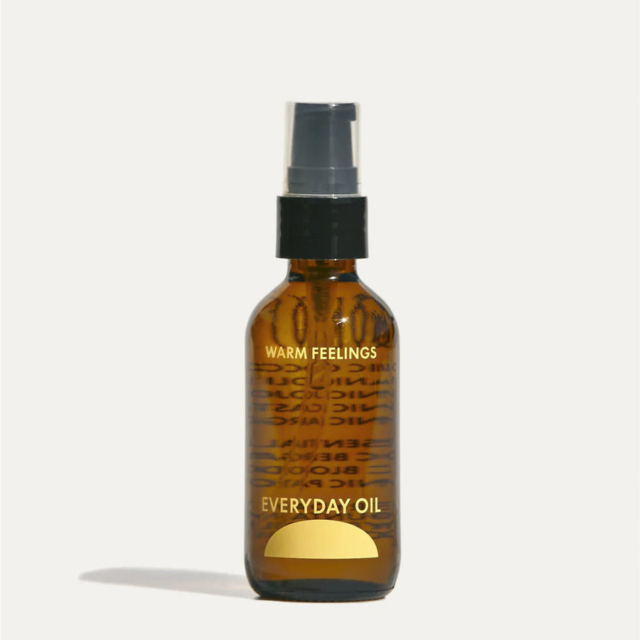 Bottle of 'Everyday Oil' with 'Warm Feelings' branding on a white background. Available at Luca Essentials in Los Angeles. 