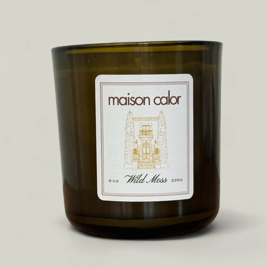 Maison Calor candle with a label on a light gray background. Available at Luca Essentials 