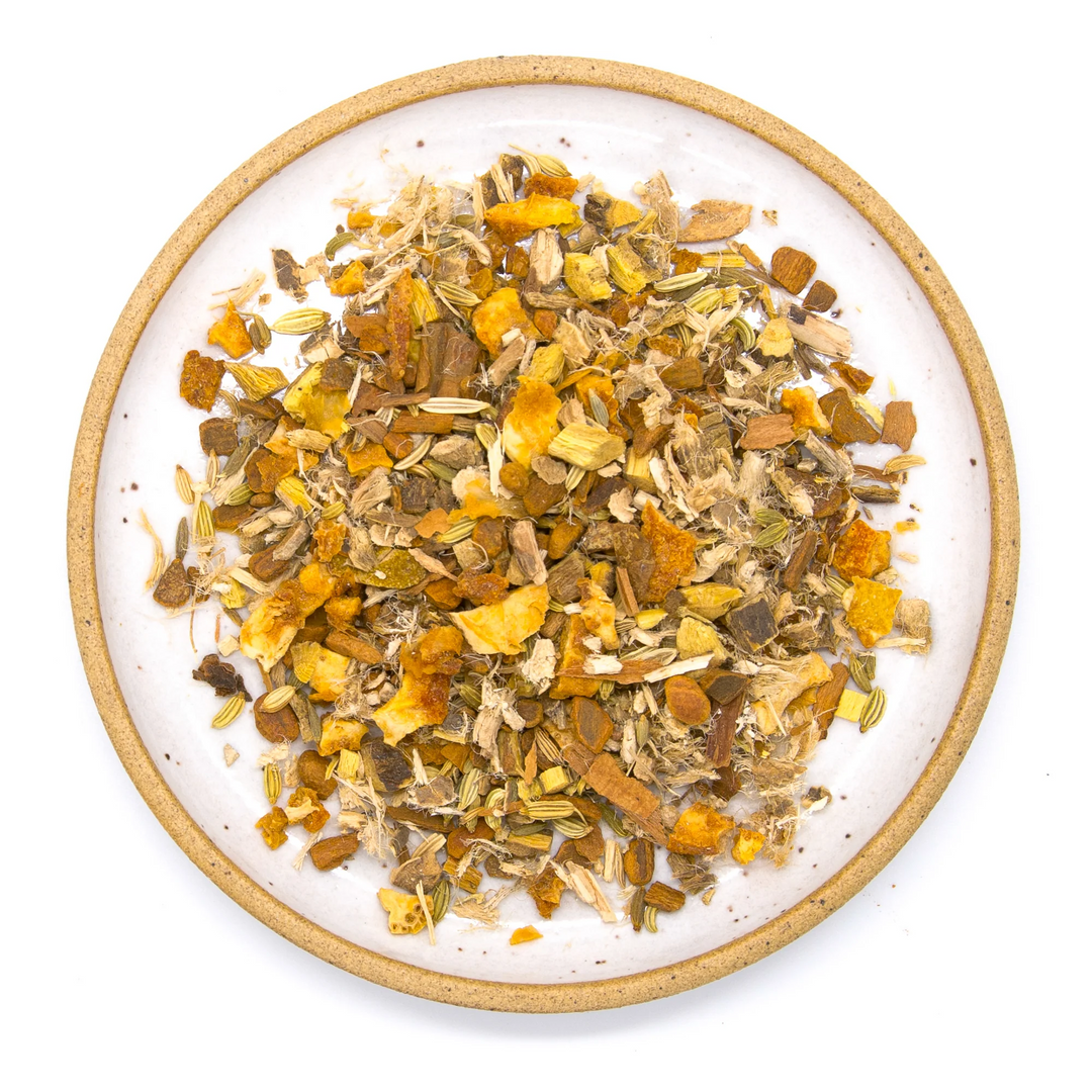 Herbal tea blend on a white plate with a wooden rim. Available at Luca Essentials in Los Angeles. 