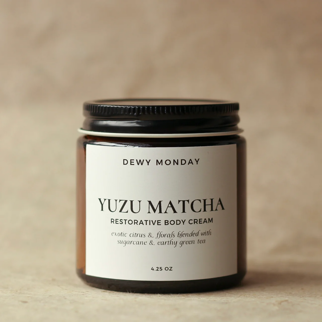 Yuzu Matcha restorative body cream jar with 'Dewy Monday' label on a beige background. Available at Luca Essentials in Los Angeles. 
